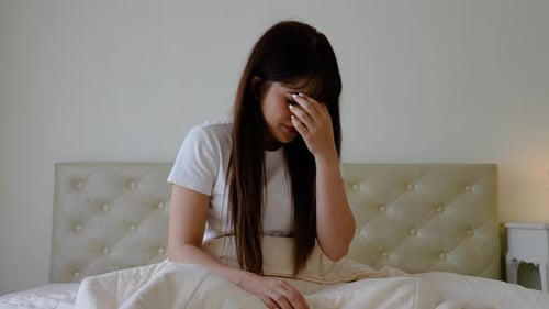 Young asian female having depression sitting alone in bedroom corner. woman headache unhappy emotion