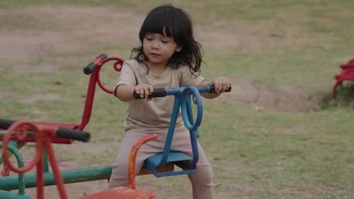 kleines Mädchen hat Spaß beim Spielen auf dem Karussell auf dem Spielplatz im Freien