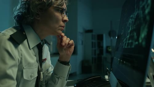 Une agente de renseignement féminine analyse le flux de surveillance par satellite