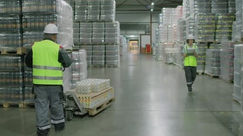 Operator Pulling Cart with Pallet of Bottles at Warehouse