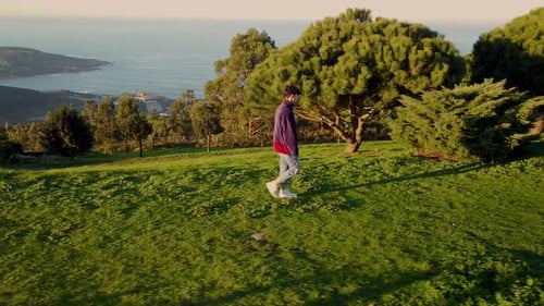 Man Walking Alone On The Verdant Landscape Overlooking Arteixo Coast In La Coruna, Galicia, Spain. T