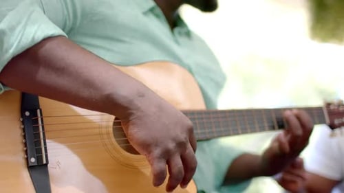Two Friends Play Guitars Indoors Together