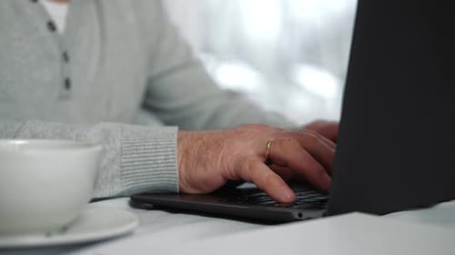 Senior Adult Typing on a Laptop Computer
