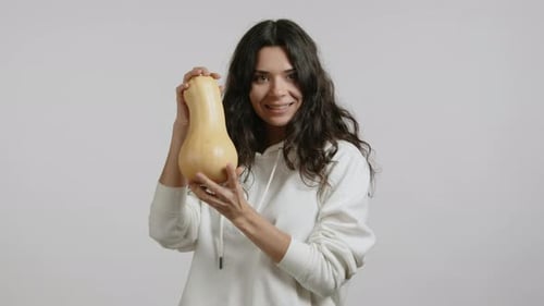 Woman Holding Butternut Squash in Studio Setting