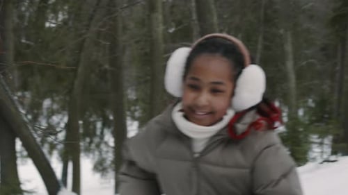 Familia negra feliz corriendo cuesta arriba una tras otra en Winter Forest