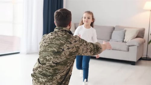 Soldier Dad Hugs Little Girl in Bright Home