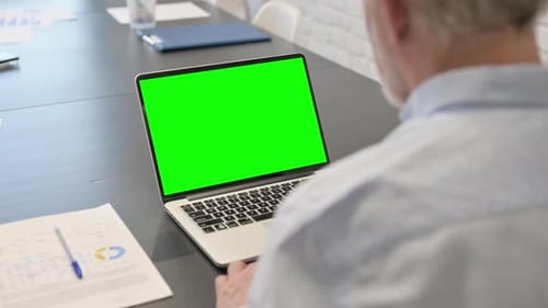 Rear View of Senior Man Using Green Screen Laptop