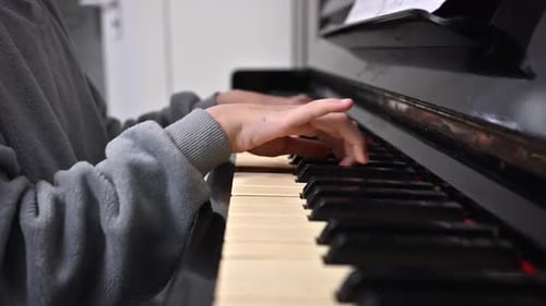 Child Plays Piano at Home, Close Up View