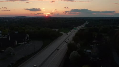 Night evening shot of busy highway at sunset. Morning sunrise as commuters travel to on interstate r