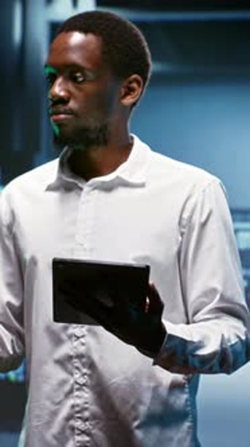 Man Using Tablet in a Dark Server Room