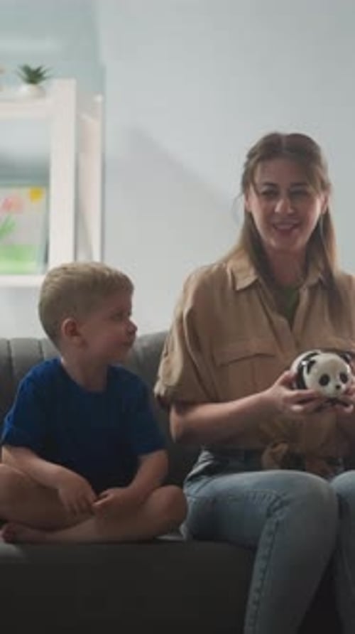 Young Mother with Children Shakes a Piggy Bank