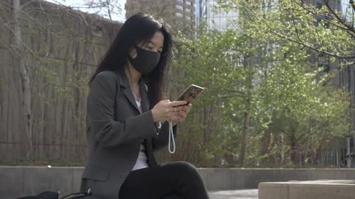 Businesswoman in Face Mask Using Smart Phone in City Park Adult