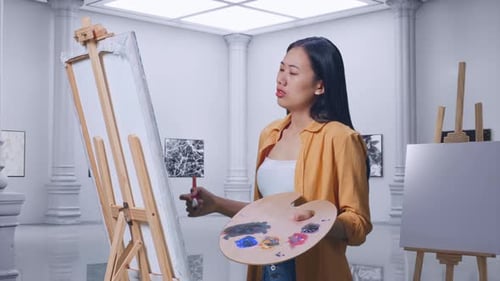 Female Shaking Her Head Unsatisfied With The Picture On Canvas While Painting In Gallery