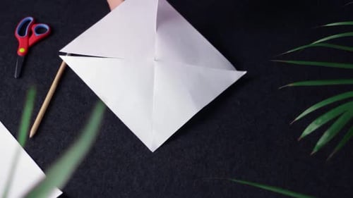 Hands Folding Paper into Four-Pointed Shape