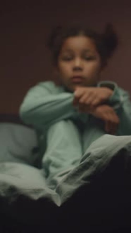 Thoughtful Child Sitting Up in Bed