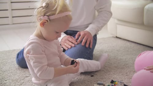 Young Girl Plays with Toys with Her Father