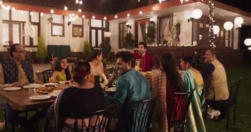 Family Celebration Dinner Under Festive Lights at Night