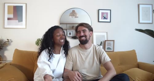 Happy Young Couple Waving and Talking at Home
