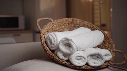 Serviettes blanches immaculées de Tranquil Home Comforts nichées dans un panier tissé