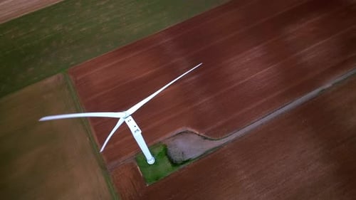 Wind Turbine Spinning in a Farm Field Aerial View