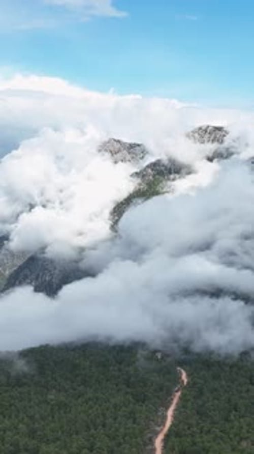 Vertical Video Aerial Perspective of CloudEnveloped Mountain Scenery Nature's Majesty Revealed