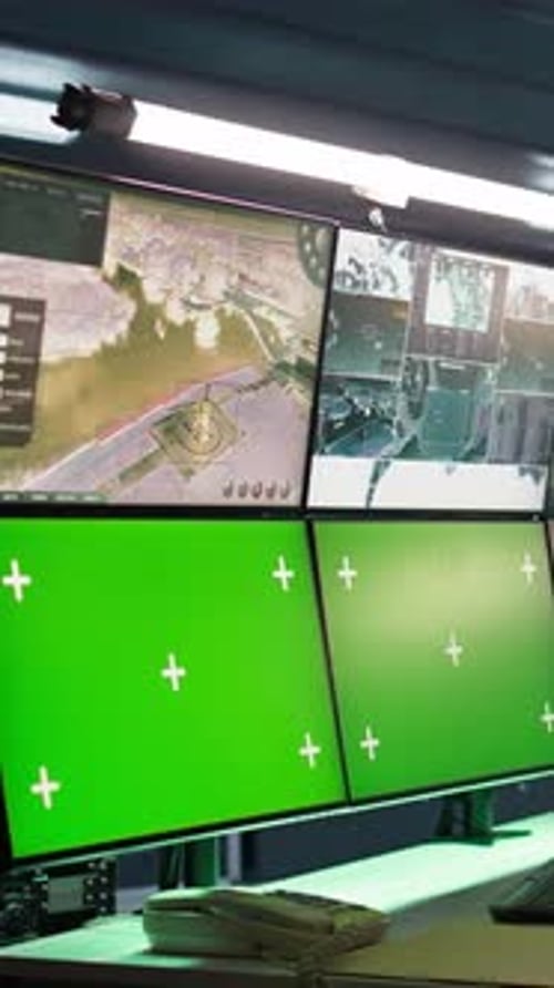 Computer Monitors Displaying Green Screen in Dark Room