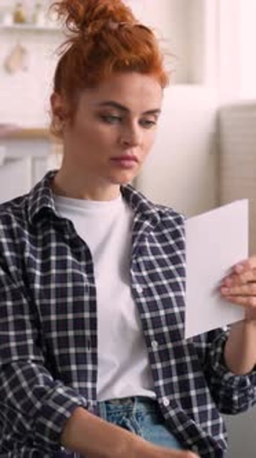 Woman Reading Letter with Happy Surprise Indoors
