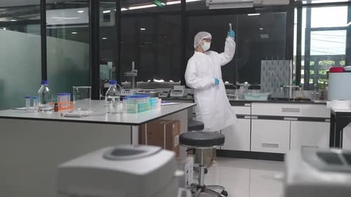 Woman Scientist Works in Laboratory Wearing Protective Gear