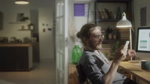 Male Freelancer Talking on Phone in Home Office