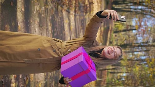 Beautiful Lady Holding Present Gift Box Taking Selfie in Park
