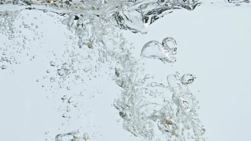 Fresh Lemons Plunging into Sparkling Water with Bubbles