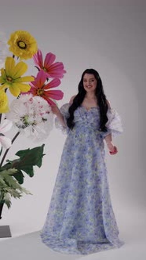 Elegant Woman Posing in Blue Floral Dress with Flowers
