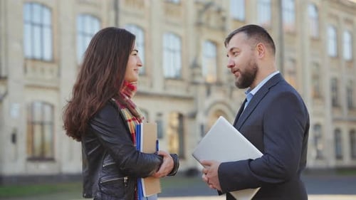 Professor and Student Talk Outside University Building