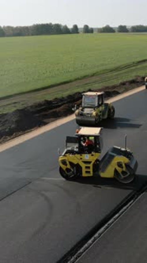 Road Rollers Compacting Fresh Asphalt on a New Road Clip