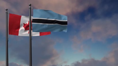 Waving Flags of Canada and Botswana Against Cloudy Sky