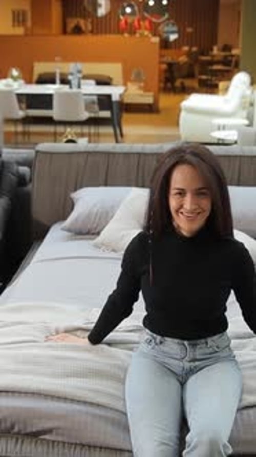 Vertical Video Woman Tests Beds at a Furniture Store to Show Bedding Options