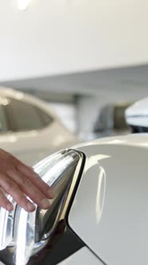 Unrecognizable Man Choosing Car in Dealership Touching Automobile Headlight Dreaming Purchase Male