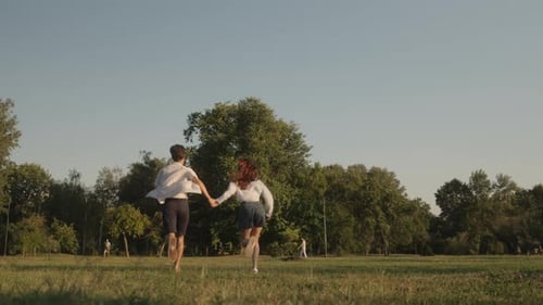 Couple Running Through The Park