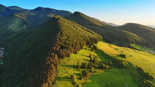 Thick pine tree forests cover the tops of the verdant mountains.