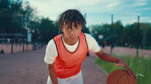 Young Streetballer Exercising with Ball on Outdoor Court Portrait in Summer Motivated Sportsman