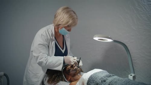 Woman Applies Facial Mask in Bright Medical Office