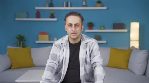 Man looking at camera with dull expression.