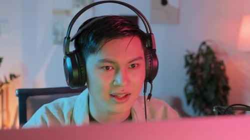 Asian Guy Playing PC Game at Home