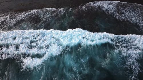 Aerial Slow Motion Capture of Powerful Ocean Waves Breaking Against Dark Sand