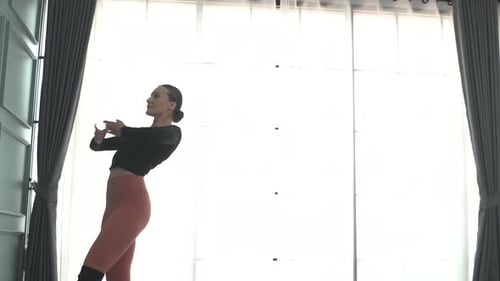 Friends practice ballet dance at studio.