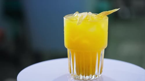 Refreshing Yellow Drink in Glass with Fruit Garnish