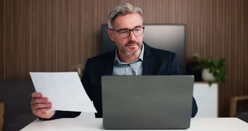 Businessman, finance and laptop with documents for statistics, budget report or revenue in office