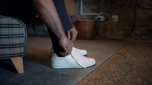 Tying Stylish White Sneakers and Suit Trousers