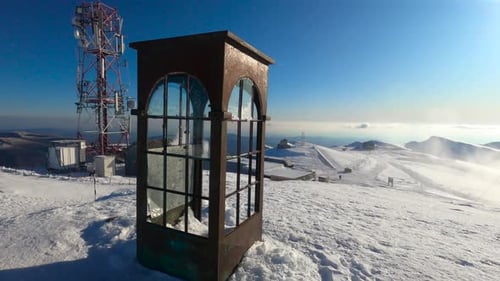 Cabine téléphonique ancienne et rouillée entourée de neige blanche au sommet de la montagne à Sinaia, en Roumanie