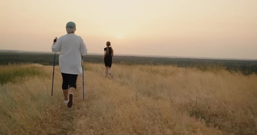 Senior and Adult Hiking Rural Trail at Sunset